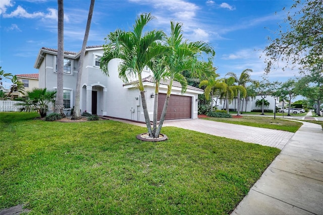 mediterranean / spanish-style home featuring stucco siding, driveway, and a front yard