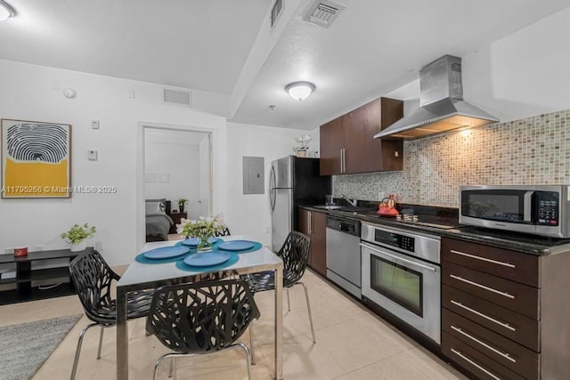 1300 Pennsylvania Ave Unit 104, Miami Beach, FL 33139 - kitchen featuring stainless steel appliances, dark countertops, visible vents, and wall chimney exhaust hood