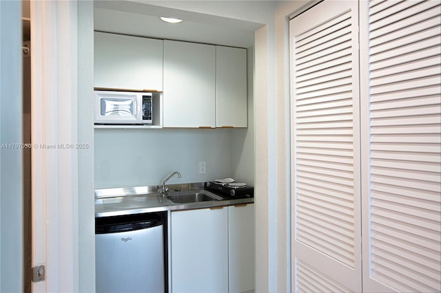 700 Biltmore Way Unit 1016, Coral Gables, FL 33134 - kitchen featuring a sink, stainless steel counters, white cabinets, white microwave, and fridge