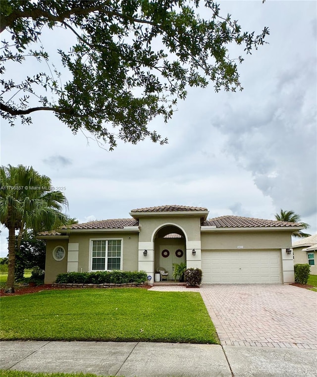 16724 NW 8th St, Pembroke Pines, FL 33028 - mediterranean / spanish-style home featuring an attached garage, a tiled roof, stucco siding, decorative driveway, and a front yard