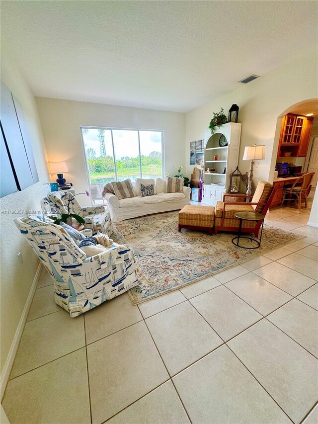 16724 NW 8th St, Pembroke Pines, FL 33028 - living room featuring a textured ceiling, visible vents, tile patterned flooring, baseboards, and arched walkways
