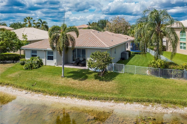 16724 NW 8th St, Pembroke Pines, FL 33028 - back of house with a patio area, a trampoline, stucco siding, a fenced backyard, and a tiled roof