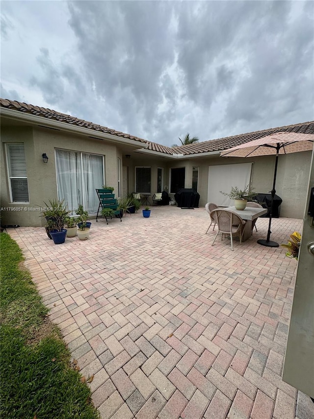 16724 NW 8th St, Pembroke Pines, FL 33028 - back of house with a patio area, a tile roof, stucco siding, and outdoor dining space
