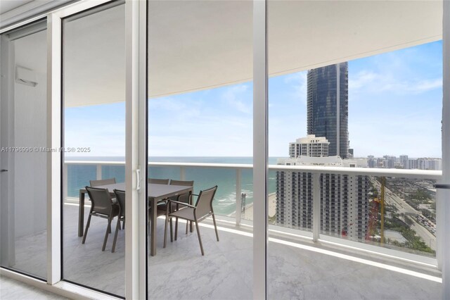 balcony featuring a city view, a water view, and outdoor dining area