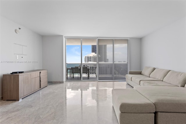 living area with expansive windows, baseboards, and light marble finish floors