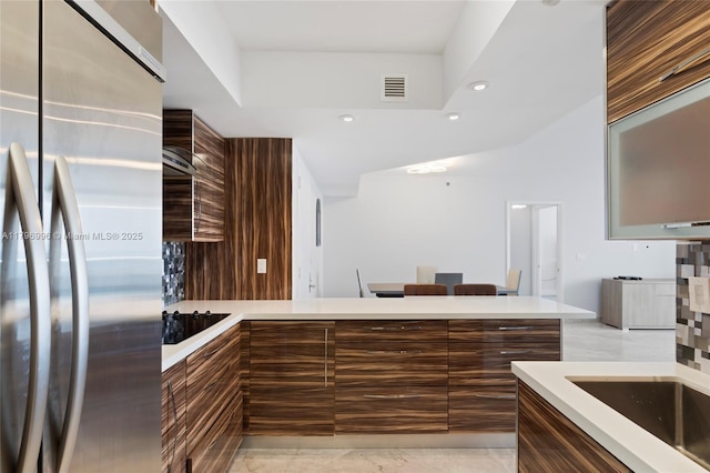 kitchen featuring stainless steel refrigerator, modern cabinets, light countertops, and recessed lighting