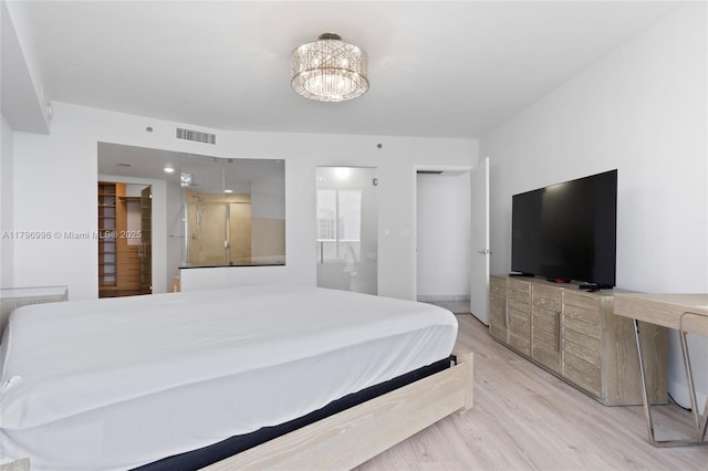 bedroom with light wood-type flooring and a chandelier