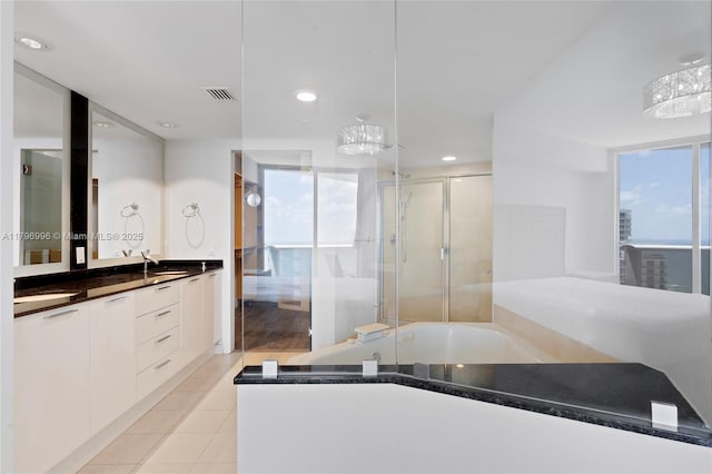 bathroom featuring a shower with door, healthy amount of natural light, a bath, and recessed lighting
