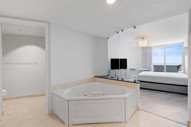 full bathroom featuring ensuite bathroom, a tub with jets, toilet, tile patterned floors, and recessed lighting
