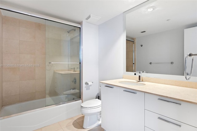 bathroom featuring tile patterned floors, toilet, shower / bath combination with glass door, and vanity