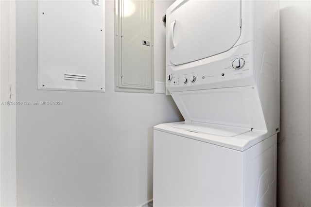 clothes washing area with estacked washer and dryer and electric panel