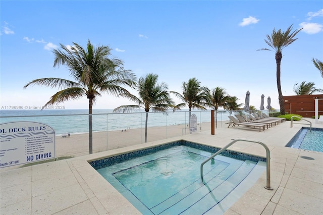 community pool featuring fence, a patio area, and a hot tub