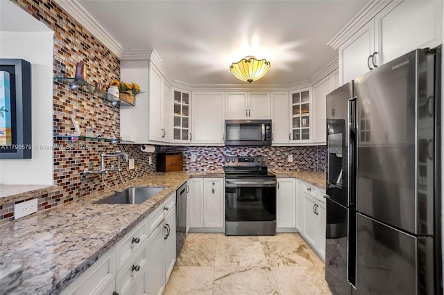kitchen with appliances with stainless steel finishes, a sink, decorative backsplash, and white cabinets