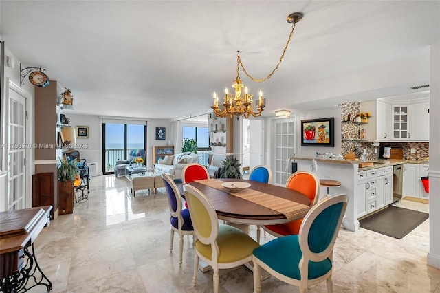 dining space with marble finish floor, a chandelier, french doors, and visible vents