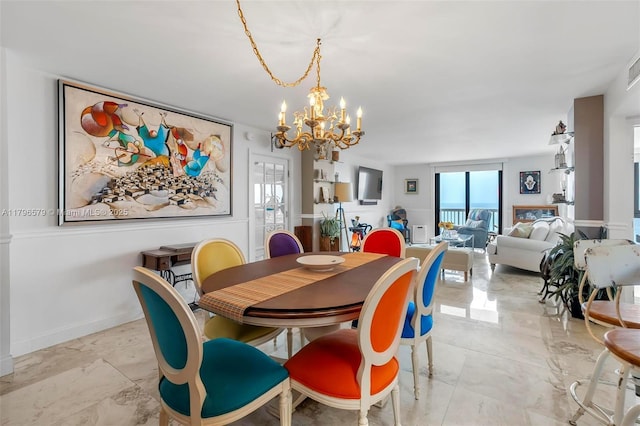 dining space with a chandelier, light marble finish flooring, and baseboards