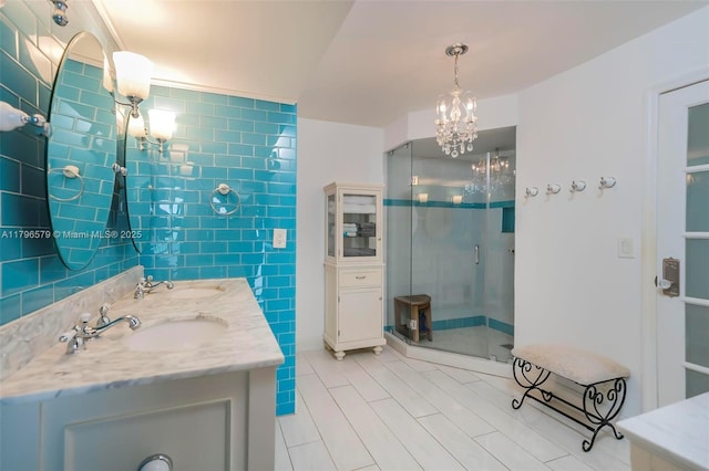 full bathroom featuring a shower stall, tile patterned floors, a chandelier, and double vanity