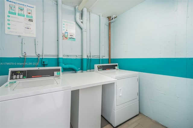 community laundry room featuring washer and clothes dryer and light tile patterned flooring