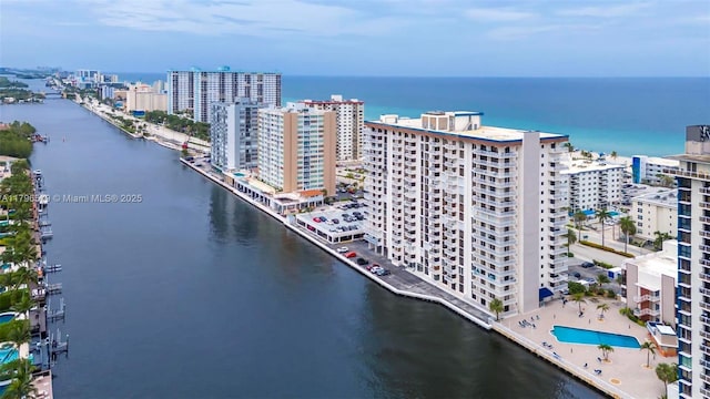 view of urban area with a large body of water, apartment complex, and a pool area