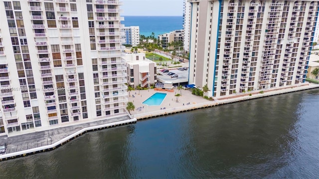 bird's eye view of a large body of water, apartment complex / building, and a pool