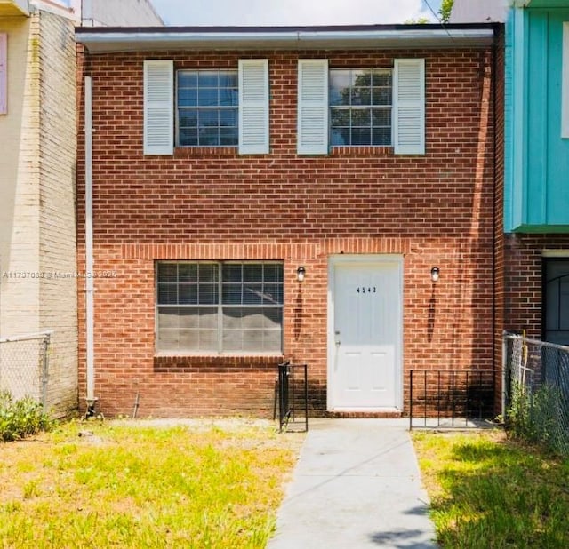 multi unit property featuring brick siding and fence
