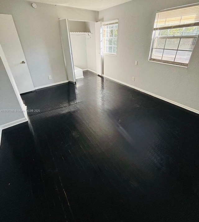 unfurnished room with baseboards and wood finished floors