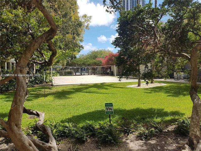 view of home's community featuring volleyball court and a lawn