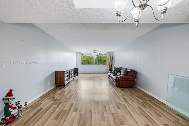 6698 N 10th Ave N Unit 218, Lake Worth, FL 33467 - living area featuring baseboards, a notable chandelier, light wood-type flooring, and a textured ceiling