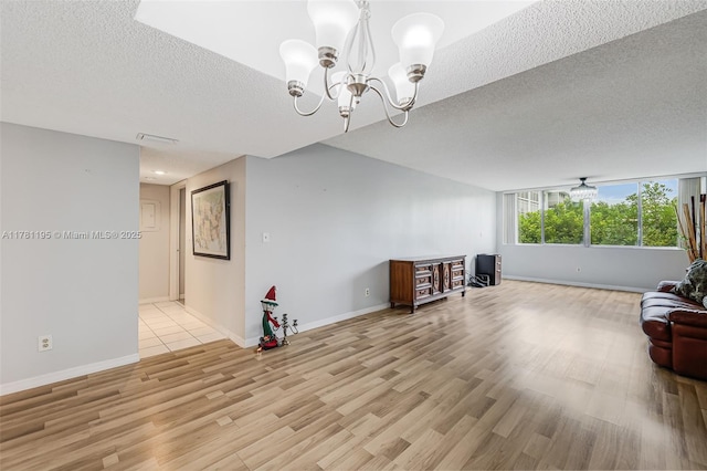 6698 N 10th Ave N Unit 218, Lake Worth, FL 33467 - living room featuring light wood finished floors, a textured ceiling, a chandelier, and baseboards