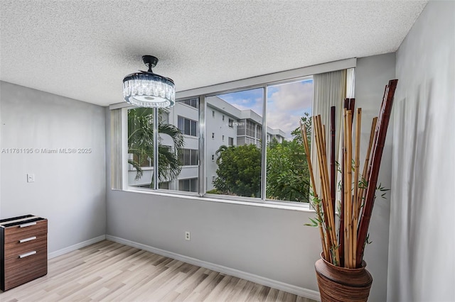 6698 N 10th Ave N Unit 218, Lake Worth, FL 33467 - unfurnished dining area featuring baseboards, a notable chandelier, a textured ceiling, and wood finished floors