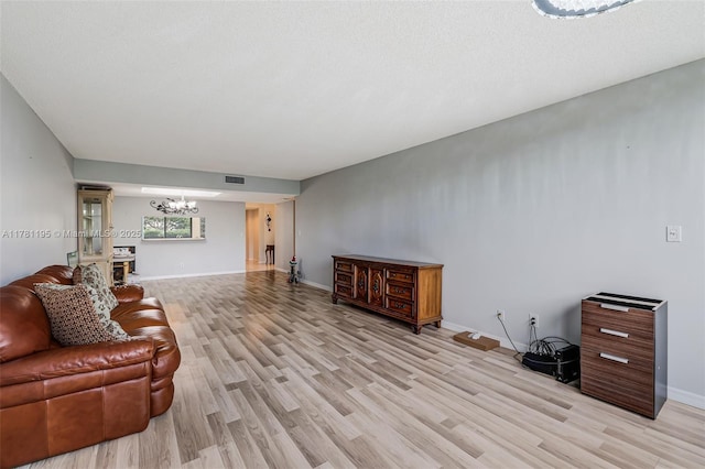 6698 N 10th Ave N Unit 218, Lake Worth, FL 33467 - living room featuring light wood-style floors, visible vents, baseboards, and a notable chandelier