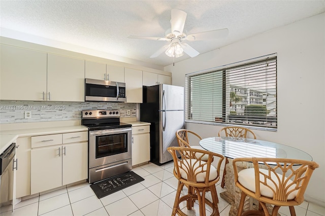 6698 N 10th Ave N Unit 218, Lake Worth, FL 33467 - kitchen featuring a ceiling fan, stainless steel appliances, a textured ceiling, light countertops, and tasteful backsplash
