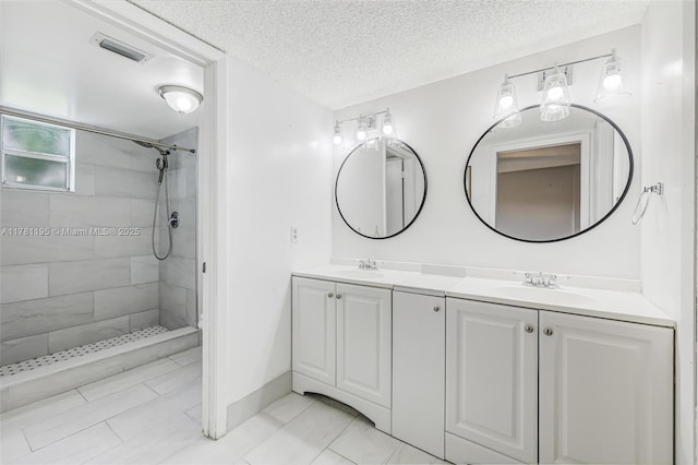 6698 N 10th Ave N Unit 218, Lake Worth, FL 33467 - full bathroom with double vanity, a textured ceiling, a tile shower, and a sink
