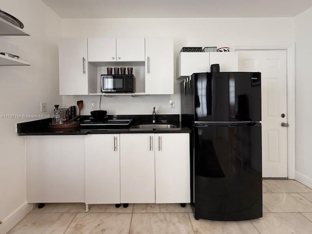 1526 Pennsylvania Ave Unit 20, Miami Beach, FL 33139 - kitchen with a sink, dark countertops, white cabinetry, baseboards, and black appliances