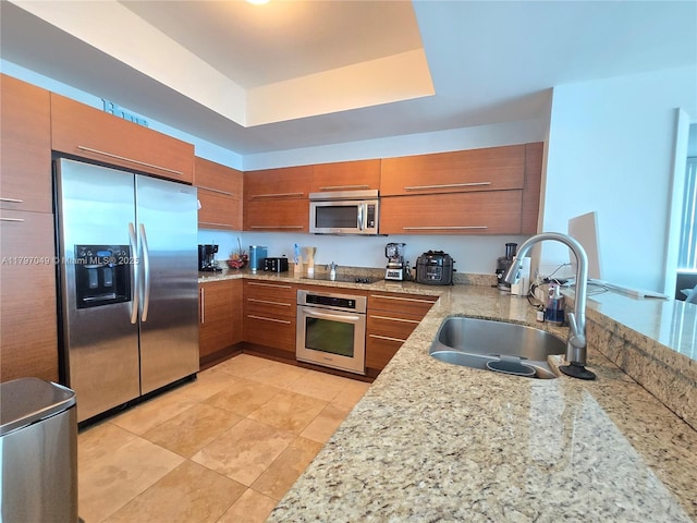 2641 N Flamingo Rd Unit 2601N, Sunrise, FL 33323 - kitchen featuring brown cabinets, a sink, appliances with stainless steel finishes, light stone counters, and light tile patterned flooring