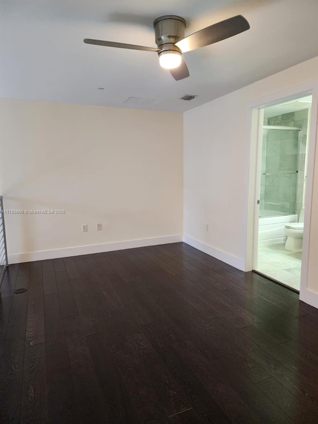empty room with dark wood finished floors, visible vents, baseboards, and a ceiling fan