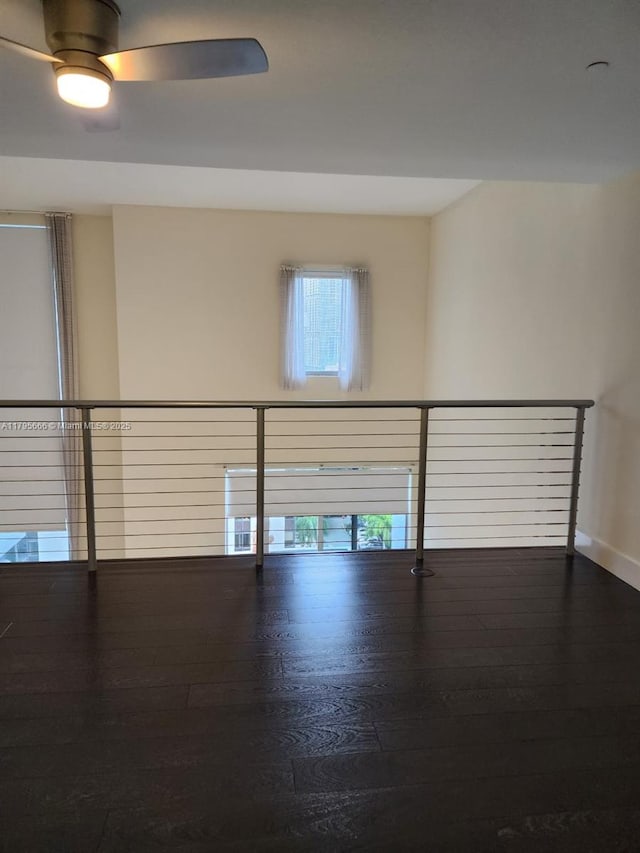 spare room with ceiling fan, baseboards, and hardwood / wood-style floors