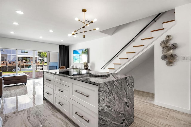kitchen with dark stone countertops, white cabinetry, black electric cooktop, a chandelier, and recessed lighting