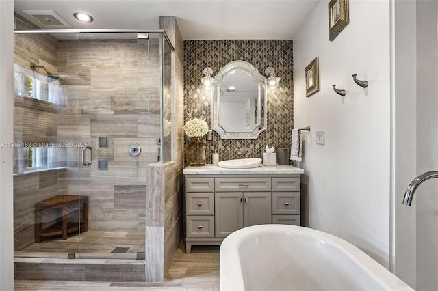 bathroom with vanity, visible vents, a shower stall, and a freestanding tub