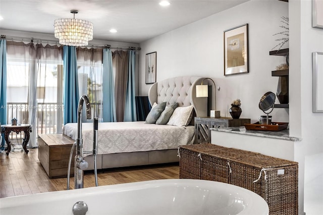 bedroom with a chandelier, recessed lighting, a sink, and wood finished floors
