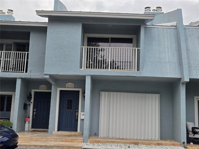 view of front of house with a balcony and stucco siding