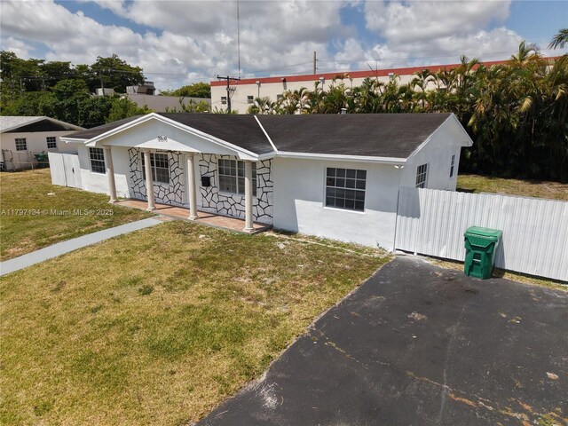 20570 NW 1st Ct, Miami Gardens, FL 33169 - single story home with stucco siding, fence, a shingled roof, a front yard, and a porch