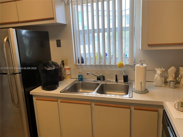 kitchen with freestanding refrigerator, light countertops, plenty of natural light, and a sink