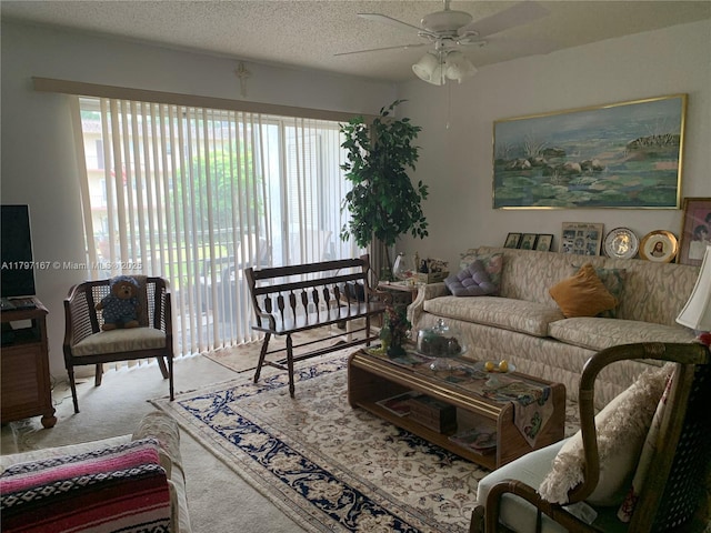 carpeted living room with ceiling fan and a textured ceiling