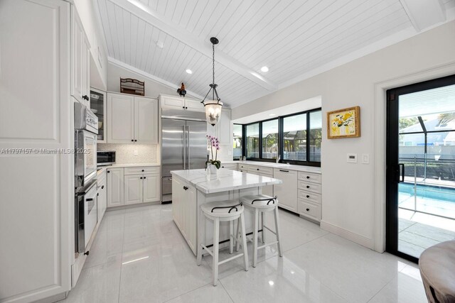15920 SW 81st Ave, Palmetto Bay, FL 33157 - kitchen with stainless steel appliances, plenty of natural light, tasteful backsplash, a breakfast bar area, and wood ceiling