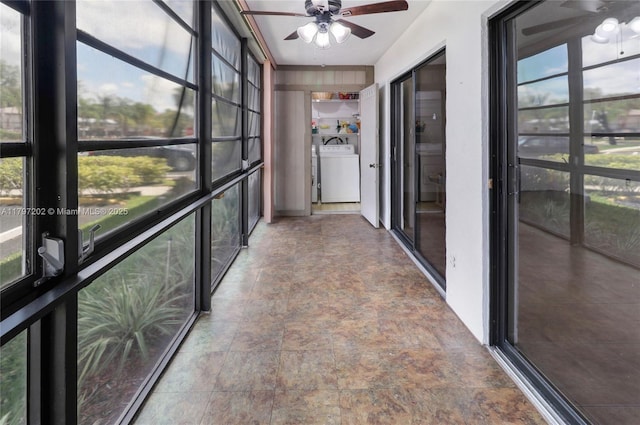 unfurnished sunroom with a wealth of natural light, stone finish floor, and a ceiling fan