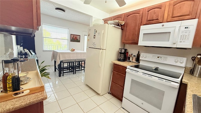 kitchen featuring a ceiling fan, light tile patterned floors, white appliances, brown cabinets, and light countertops