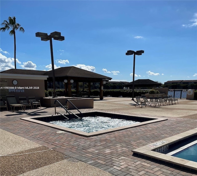 view of community with a gazebo, a patio, and a jacuzzi