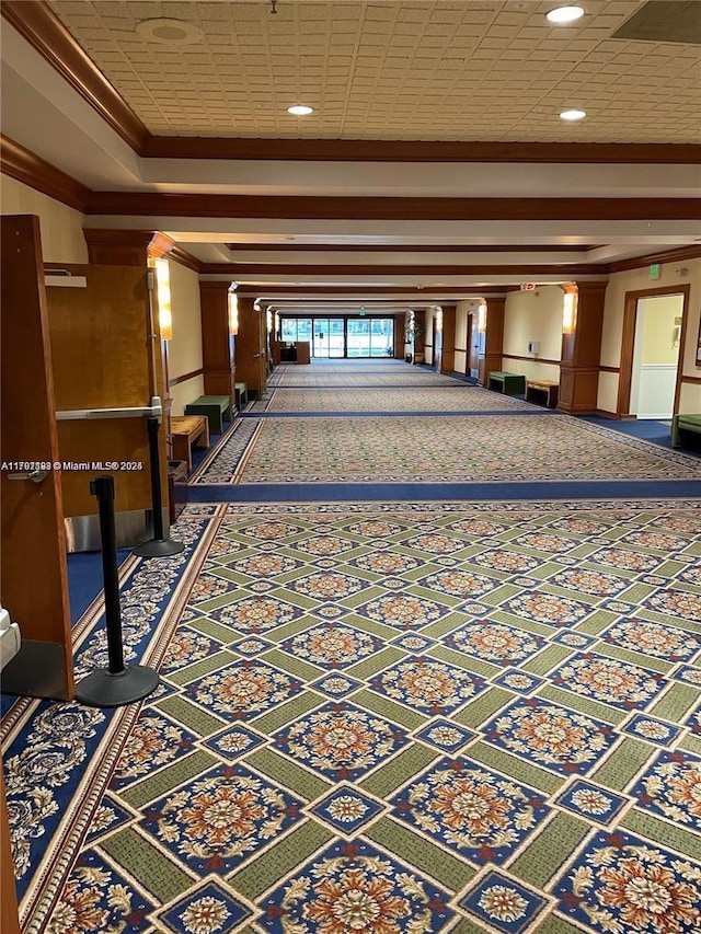corridor with carpet, a tray ceiling, crown molding, baseboards, and recessed lighting