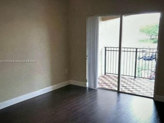 empty room with wood finished floors and baseboards