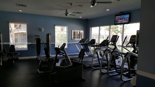 workout area with a wealth of natural light, visible vents, and a ceiling fan